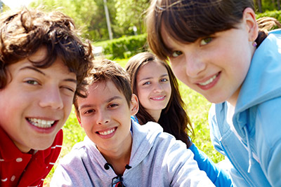 Four teenagers outdoors, smiling